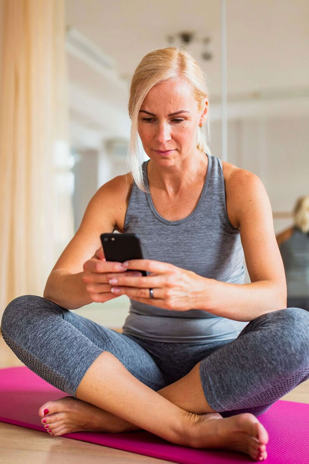 Femme en tenue de sport qui regarde son téléphone
